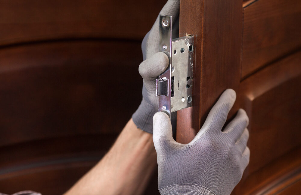 Mężczyzna, który wie jak zamontować wkładkę do drzwi, instaluje wkładkę do zamka